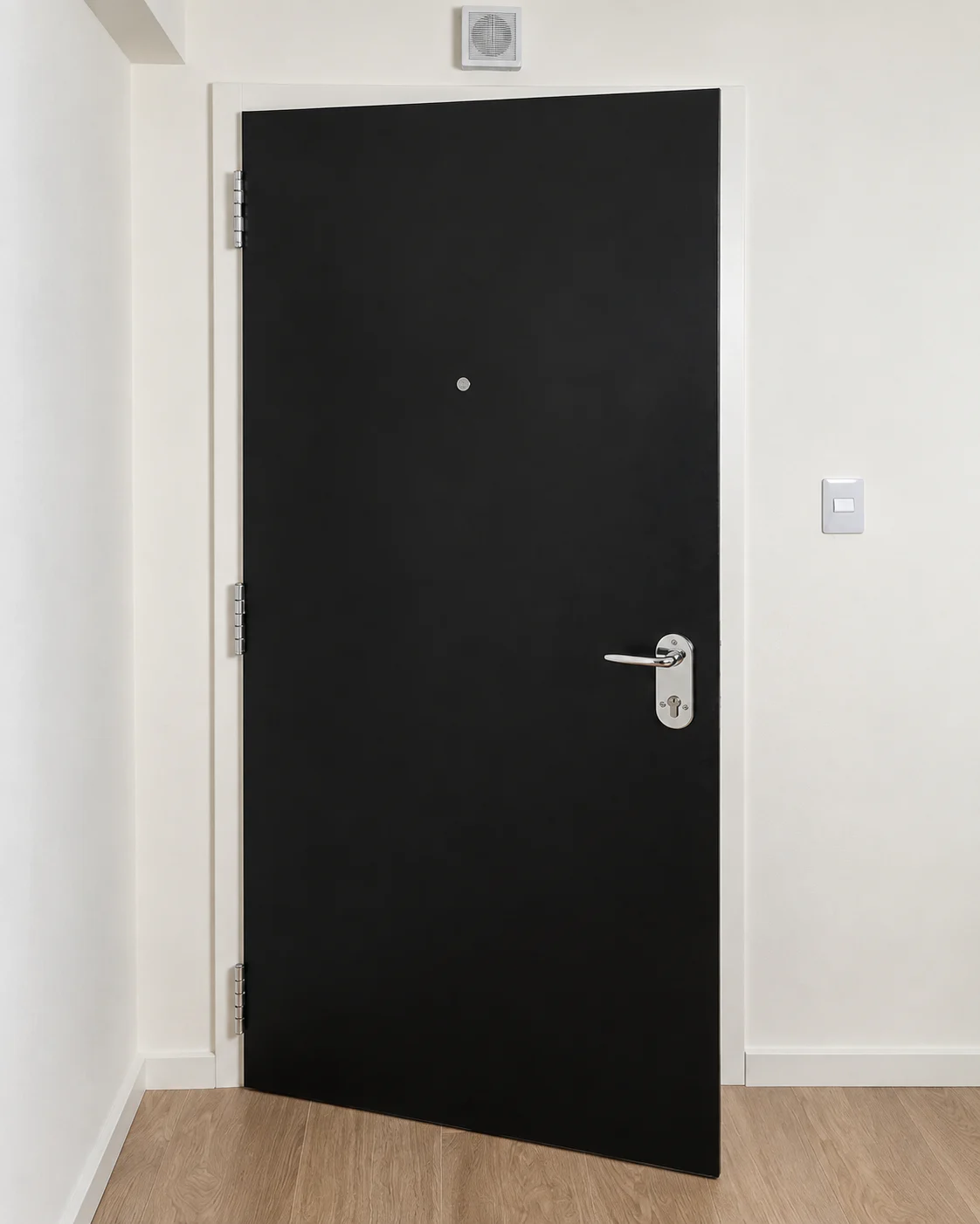 Puerta negra mate entreabierta en un pasillo claro