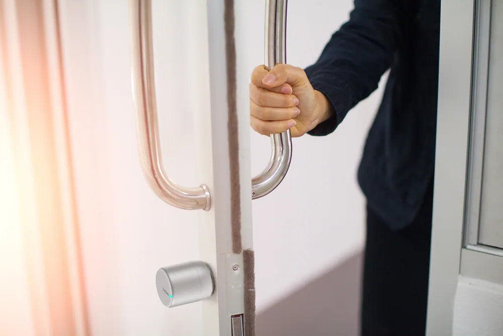 Persona abriendo una puerta de acceso comercial